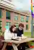 Male and female students sitting at a picnic table looking at a brochure