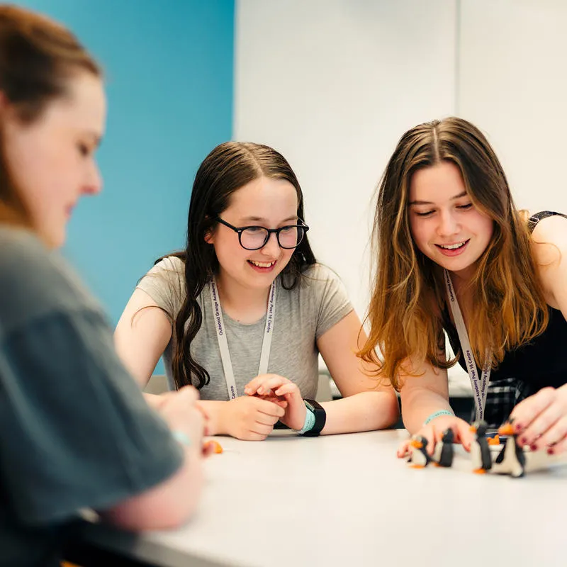 Three students completing a group task around a table