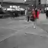 Blurred women in red in forground and a busy city street