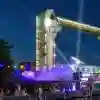 a music festival at night with the Hull tidal barrier in the background