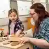 A student teacher playing with a child in early years education space