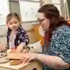 A student helping a child with wooden toys