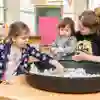 Children and tutor playing with animal toys in the classroom