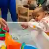 A child engaged in sensory play in a classroom
