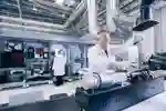 A researcher pours chemicals into machinery at the Aura Innovation Centre