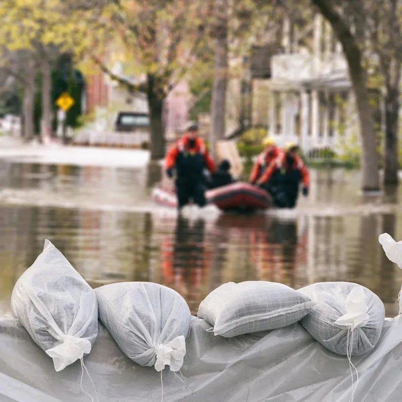 A group of rescuers using an inflatable raft rescue victims of flooding