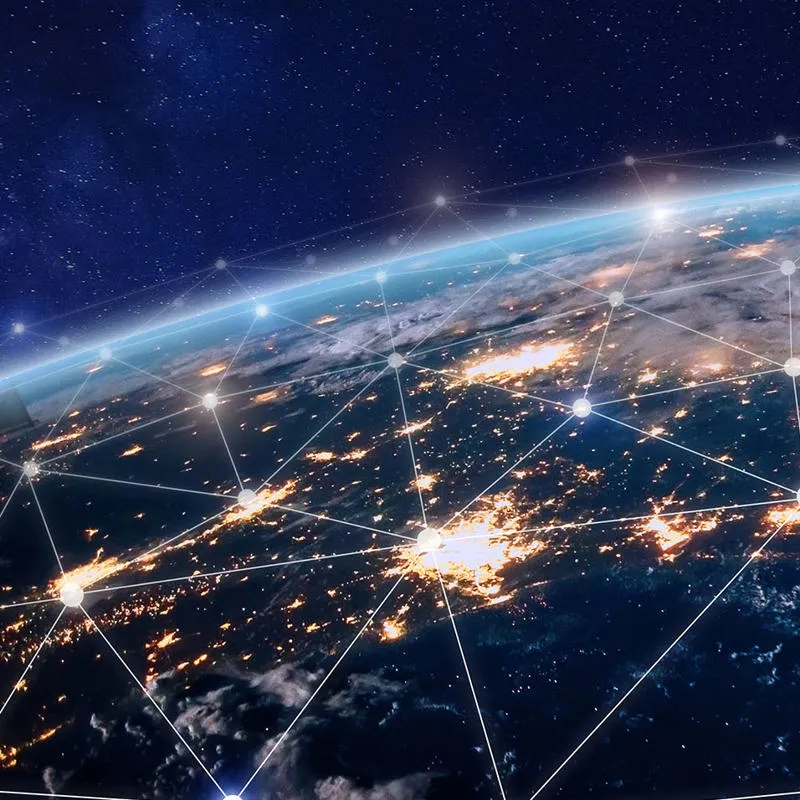 The globe from space with countries lit up and a network of lines over the top