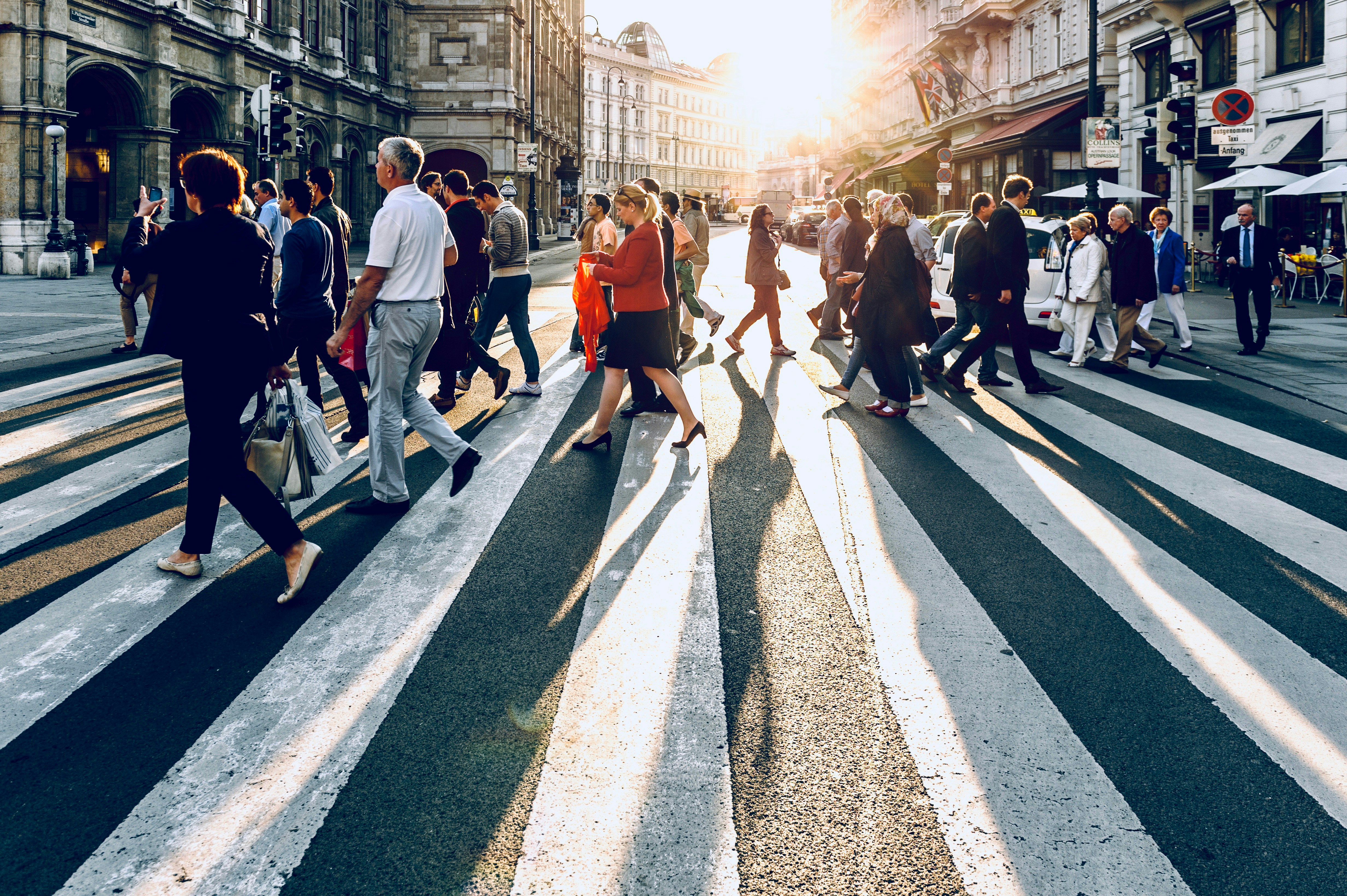 Crowd of people walking across a road crossing