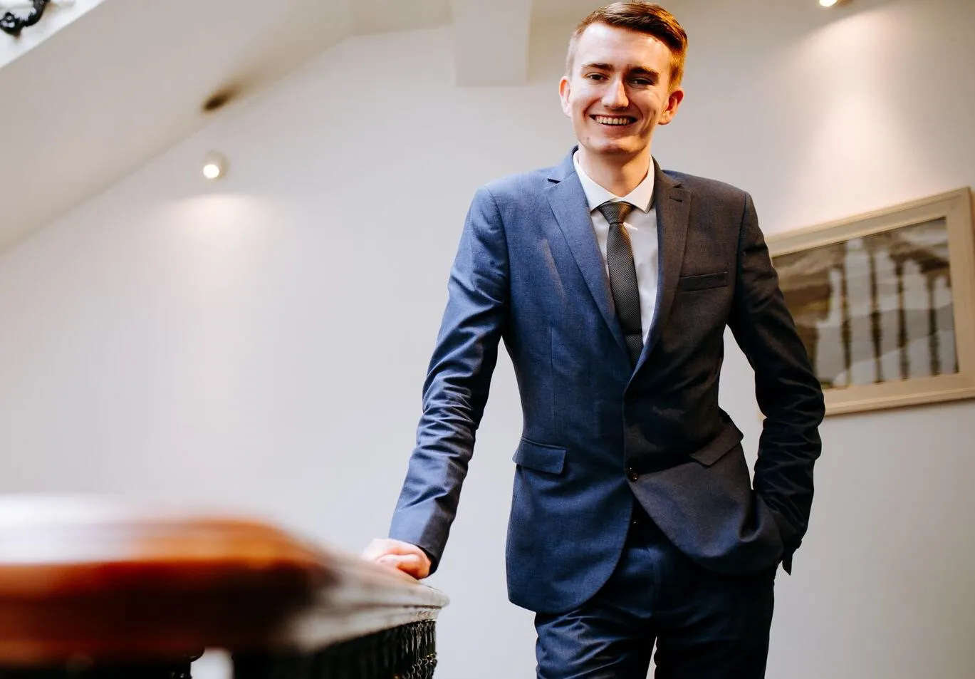 Smartly-dressed Politics student, James Parker, casually leaning and smiling to the camera