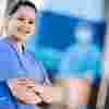 An ODP student in surgical scrubs standing outside the Allam medical building