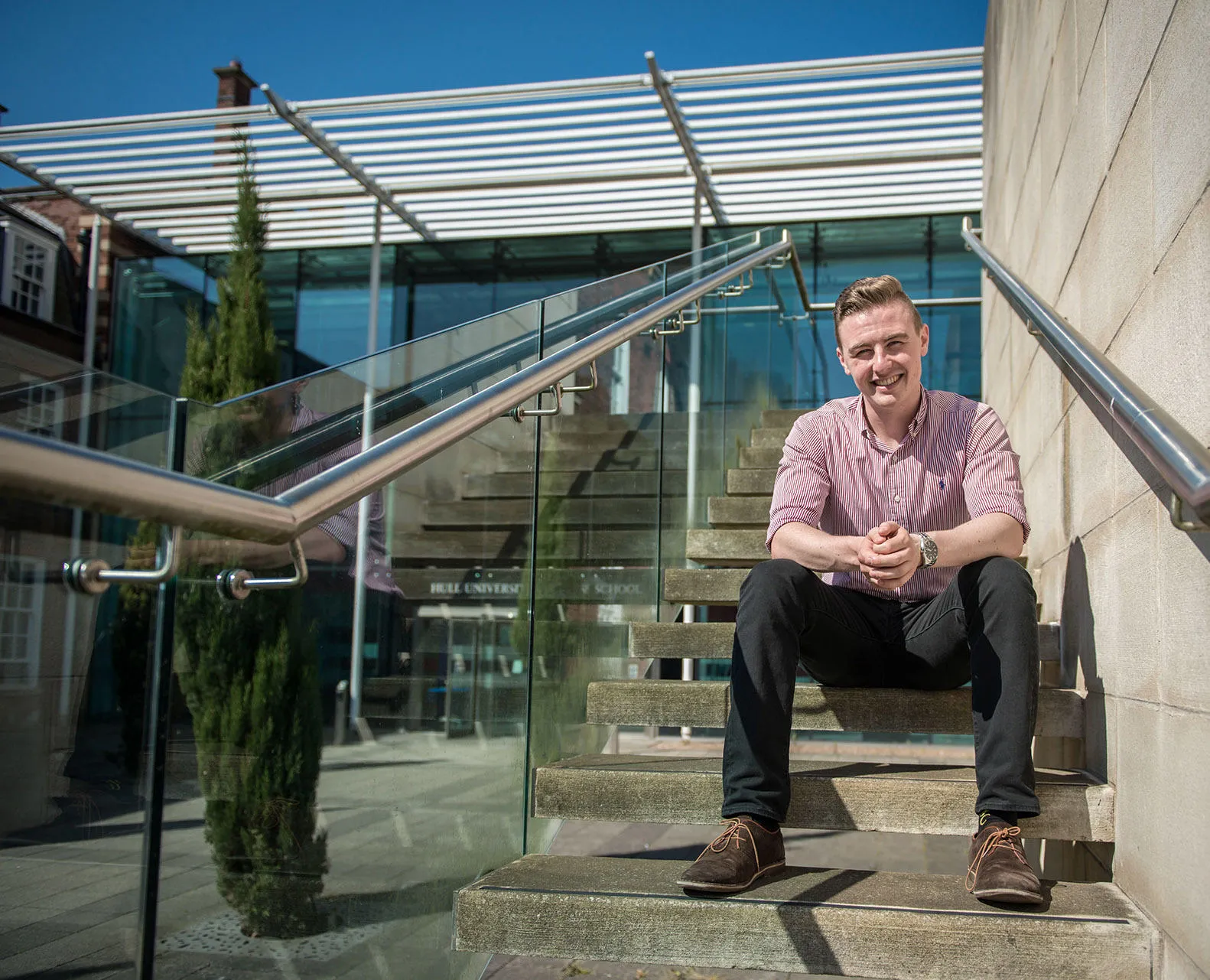 A student seated on building steps