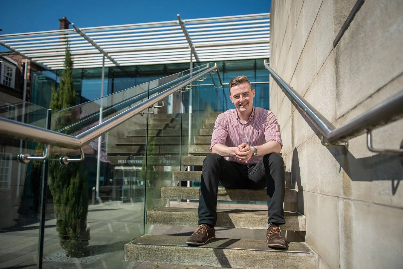 A student seated on building steps