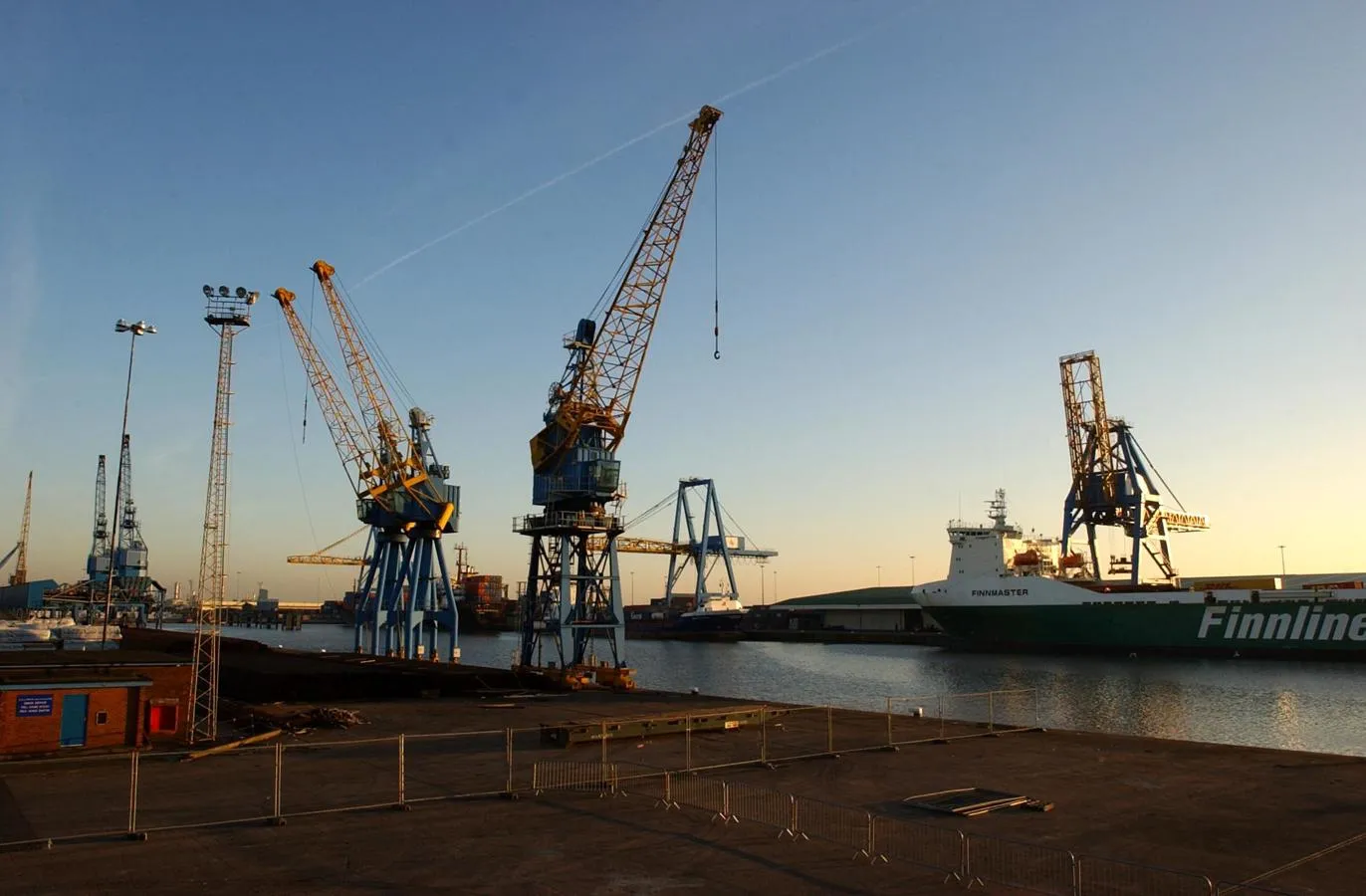 Cranes at a dockside at sunset