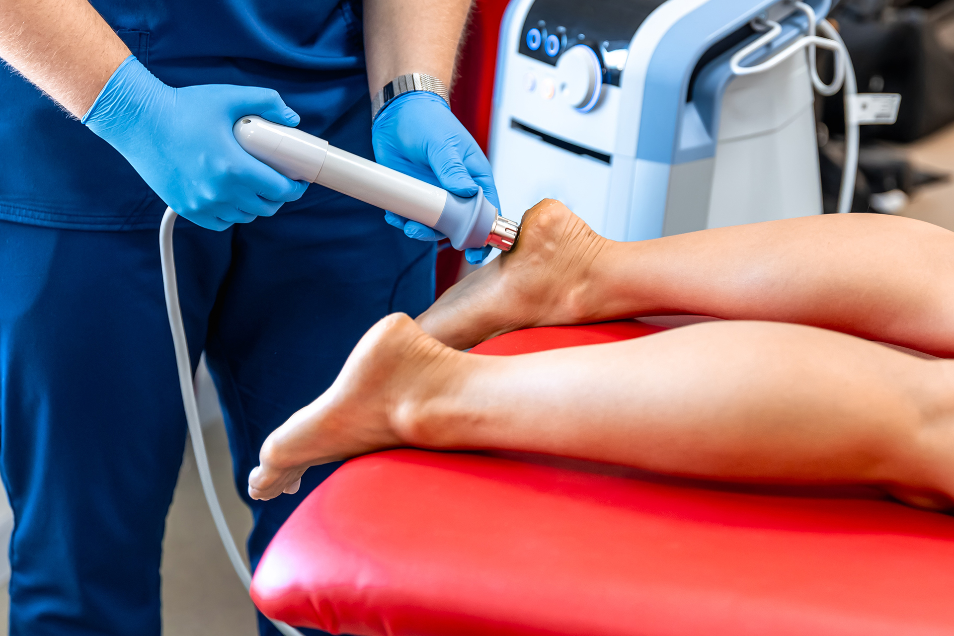 A clinician administers shockwave therapy to a patient's foot