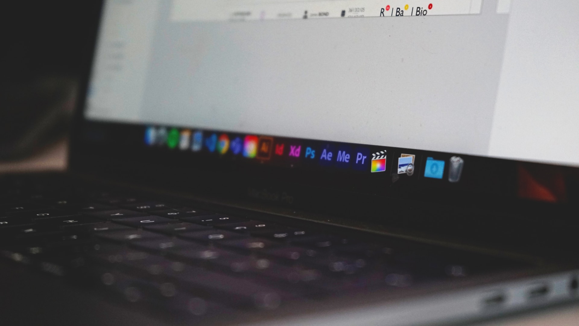 Close-up of laptop screen showing Adobe applications