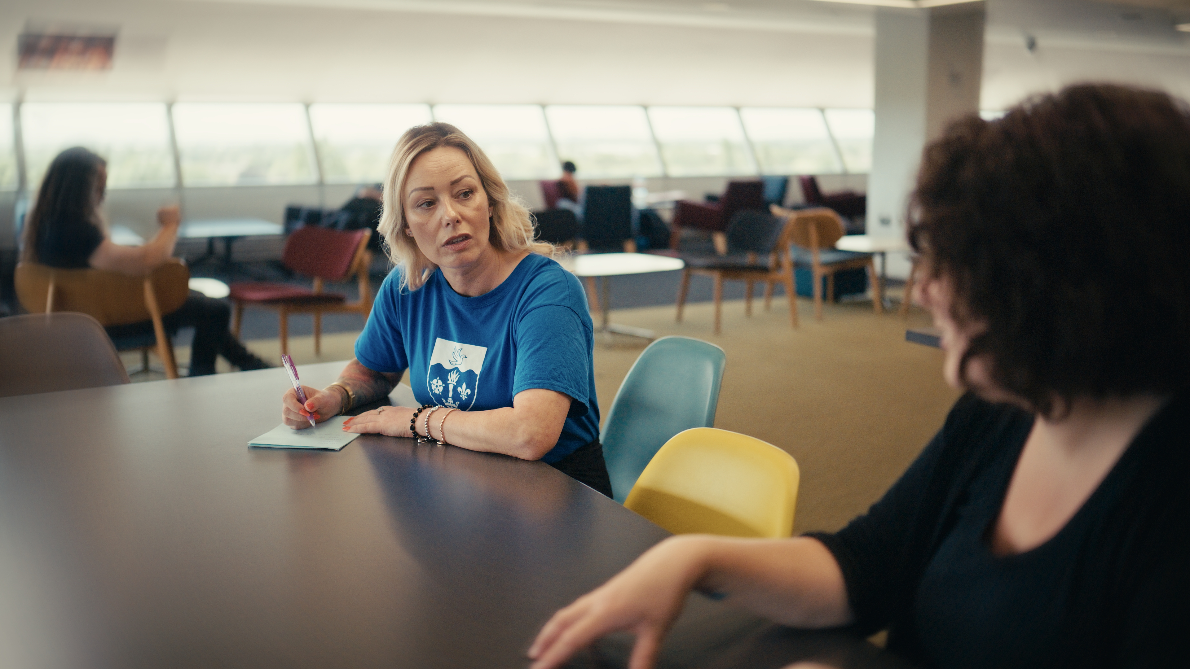 Foundation year student Lara catting with a tutor in the library