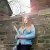 A Criminology student leaning against a wall outside Hull Prison