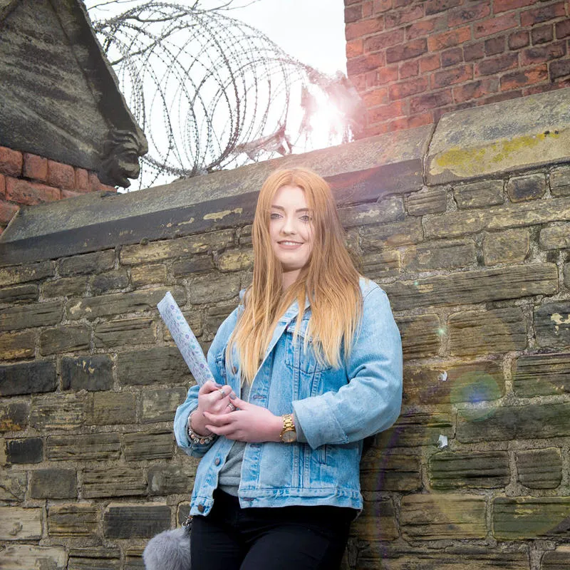 A Criminology student leaning against a wall outside Hull Prison