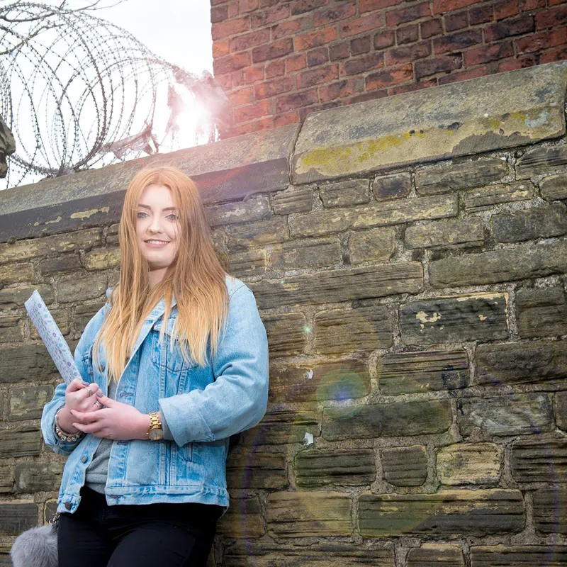 A Criminology student leaning against a wall outside Hull Prison