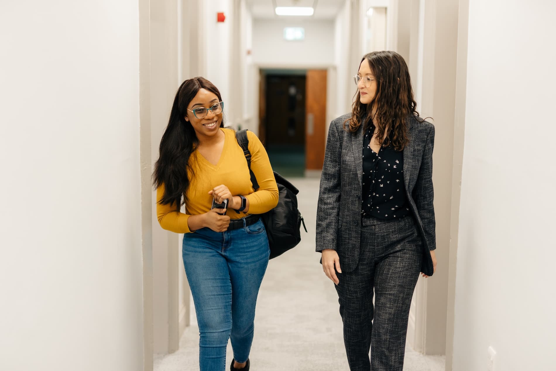 Two students walking through the Legal Advice Centre corridor
