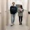 Two students walking down the Legal Advice Centre corridor carrying paperwork