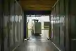A forklift truck driver reverses from an empty shipping container