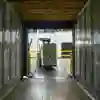 A forklift truck driver reverses from an empty shipping container