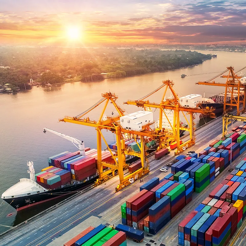 Busy dockside scene with ship, containers and sunset