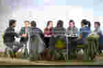 a group of students sat at a large table in a library study room
