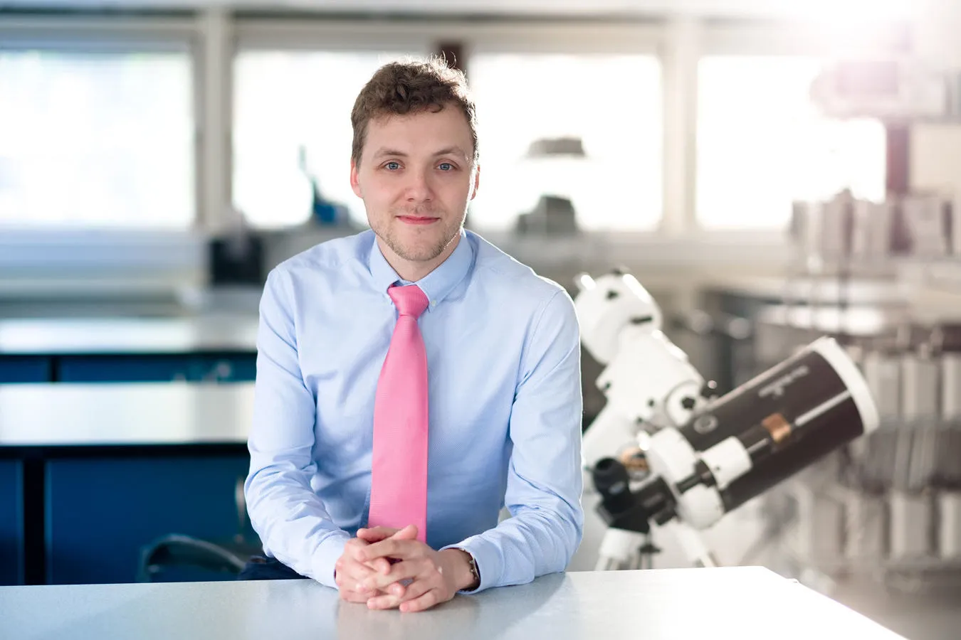 Mikkel Kristensen sitting at table in physics laboratory at the University of Hull