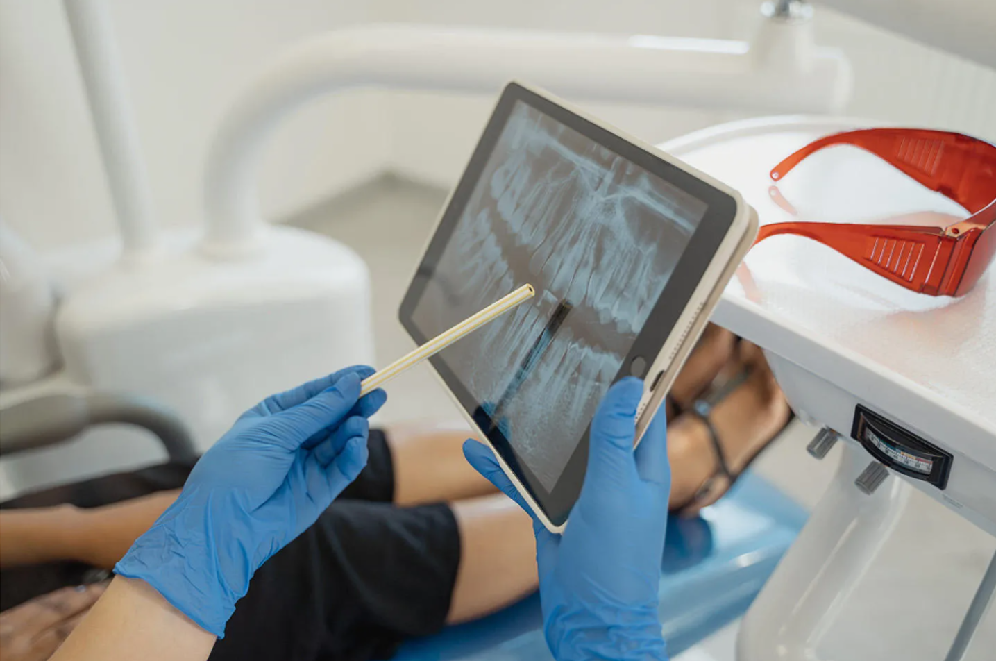 Health practioner showing patient an x-ray of their mouth. 