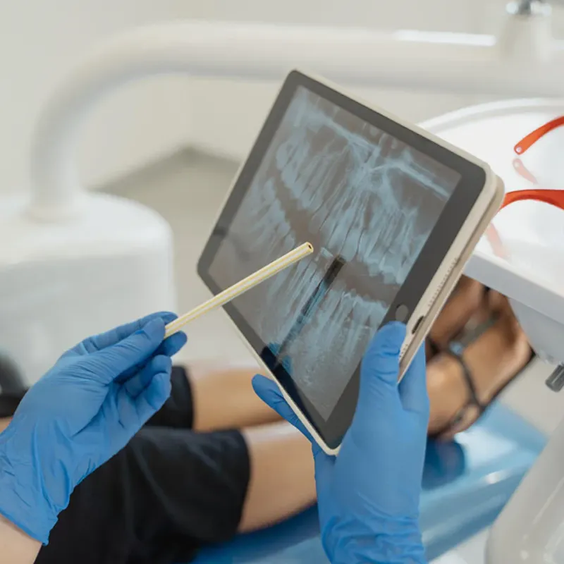Health practioner showing patient an x-ray of their mouth.