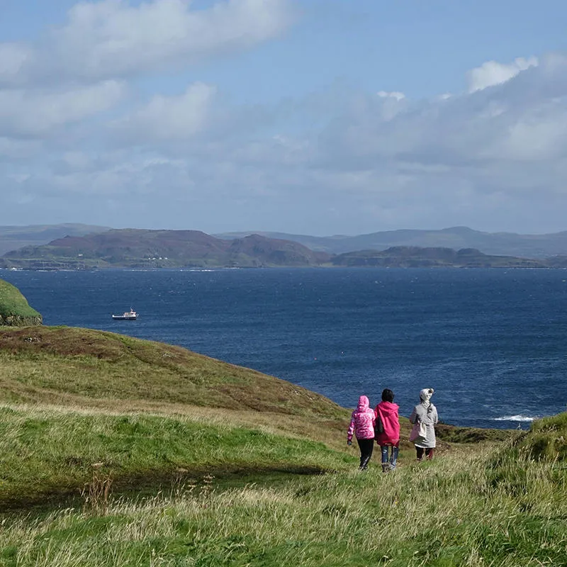 Mull coastline with three people walking towards the shore