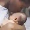 A mother kisses the top of a newborn baby's head