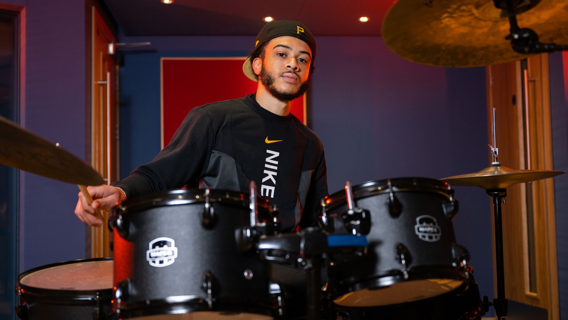 A student playing the drums in a studio