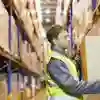 worker in hard hats and bright vests at a warehouse