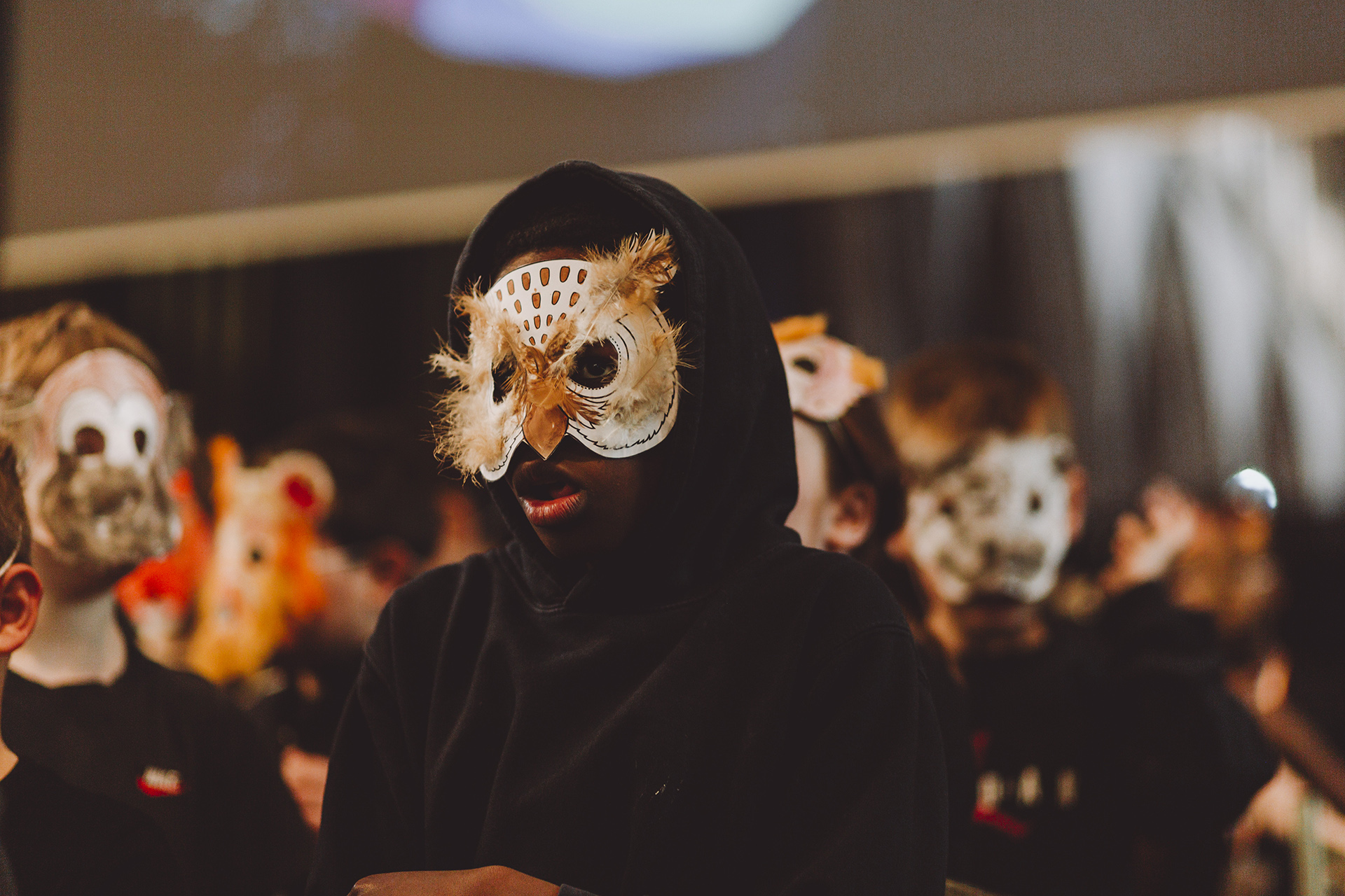 Children in black cloaks and handmade animal masks