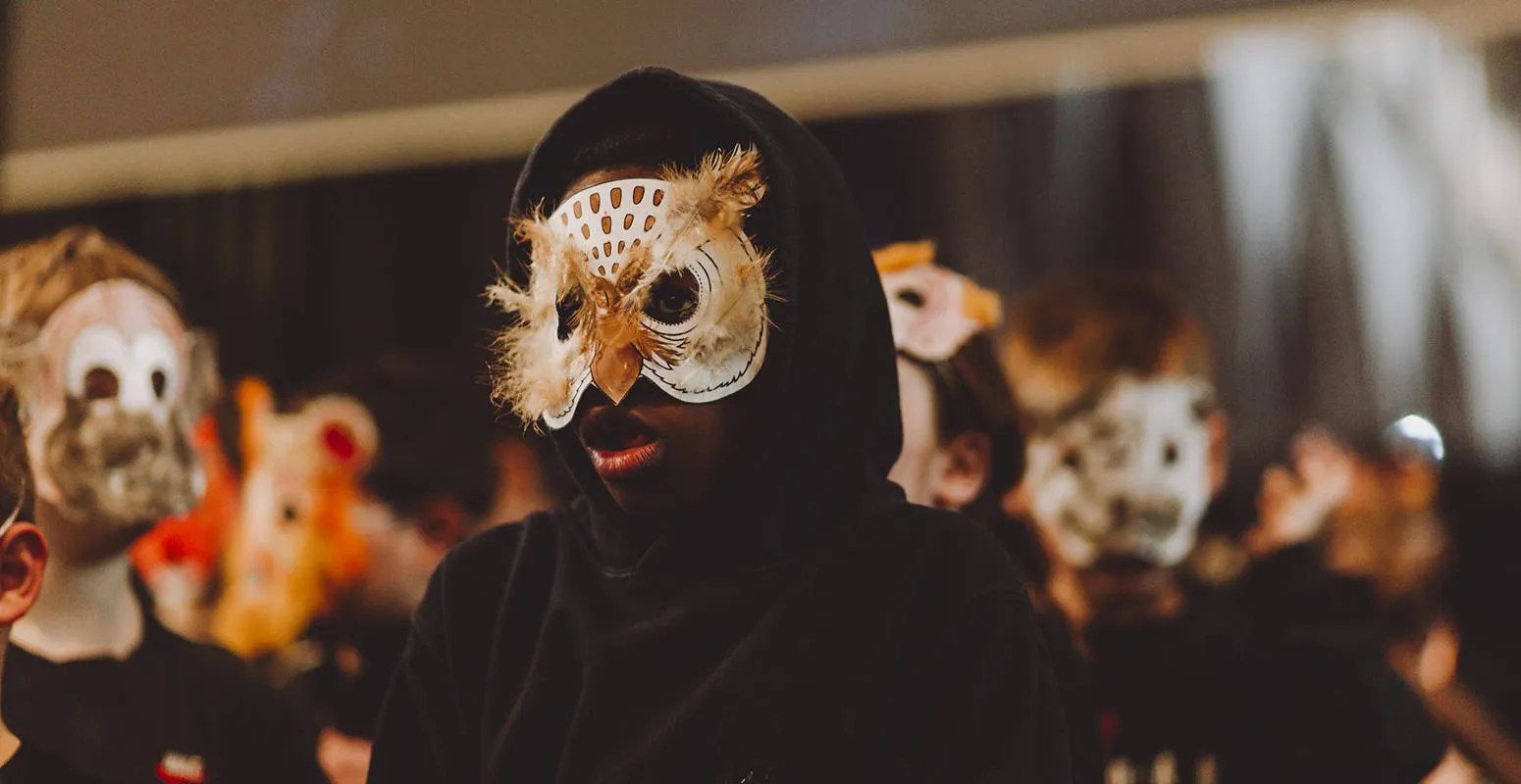 Children in black cloaks and handmade animal masks