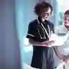 Two nurses reading from a clipboard