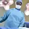 ODP student Olayemi Elizabeth Ajayi stands in scrubs at an operating table under the lights