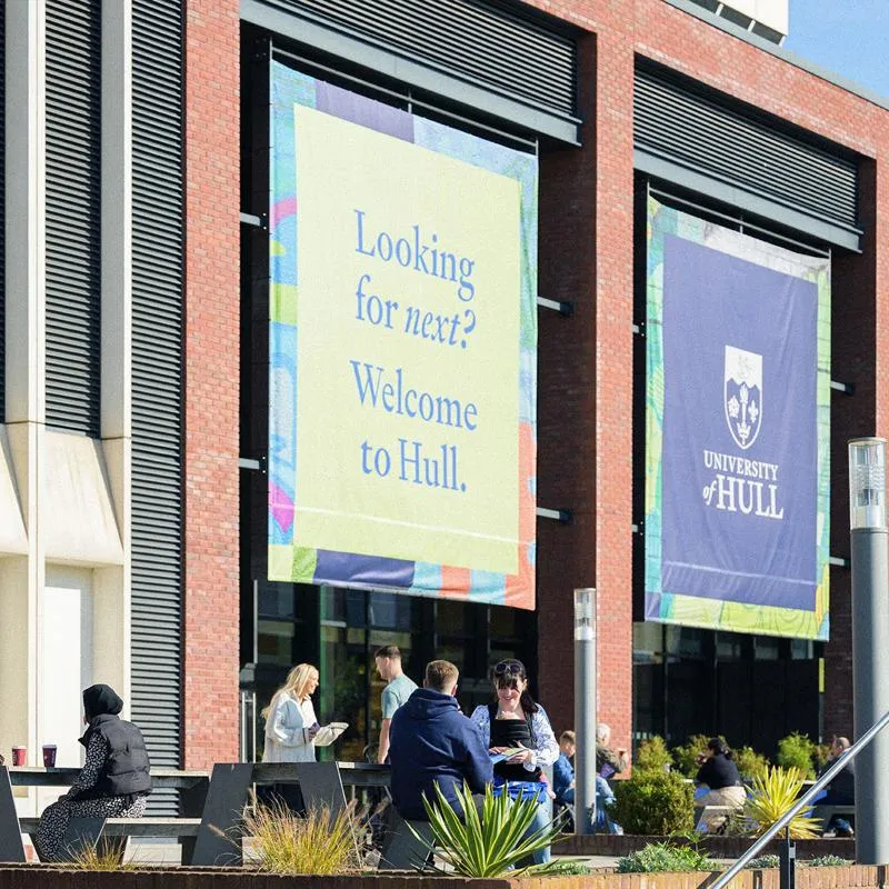 Students enjoying an open day with the library building in the background