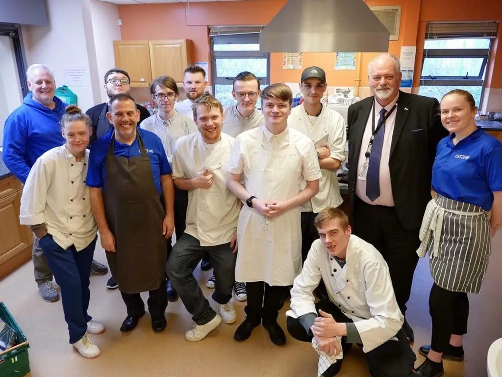 A group pf young people in chef uniforms with the Humberside Police and Crime Commissioner Jonathan Evison