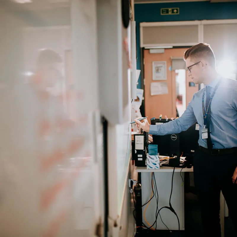 Teacher writing on a whiteboard