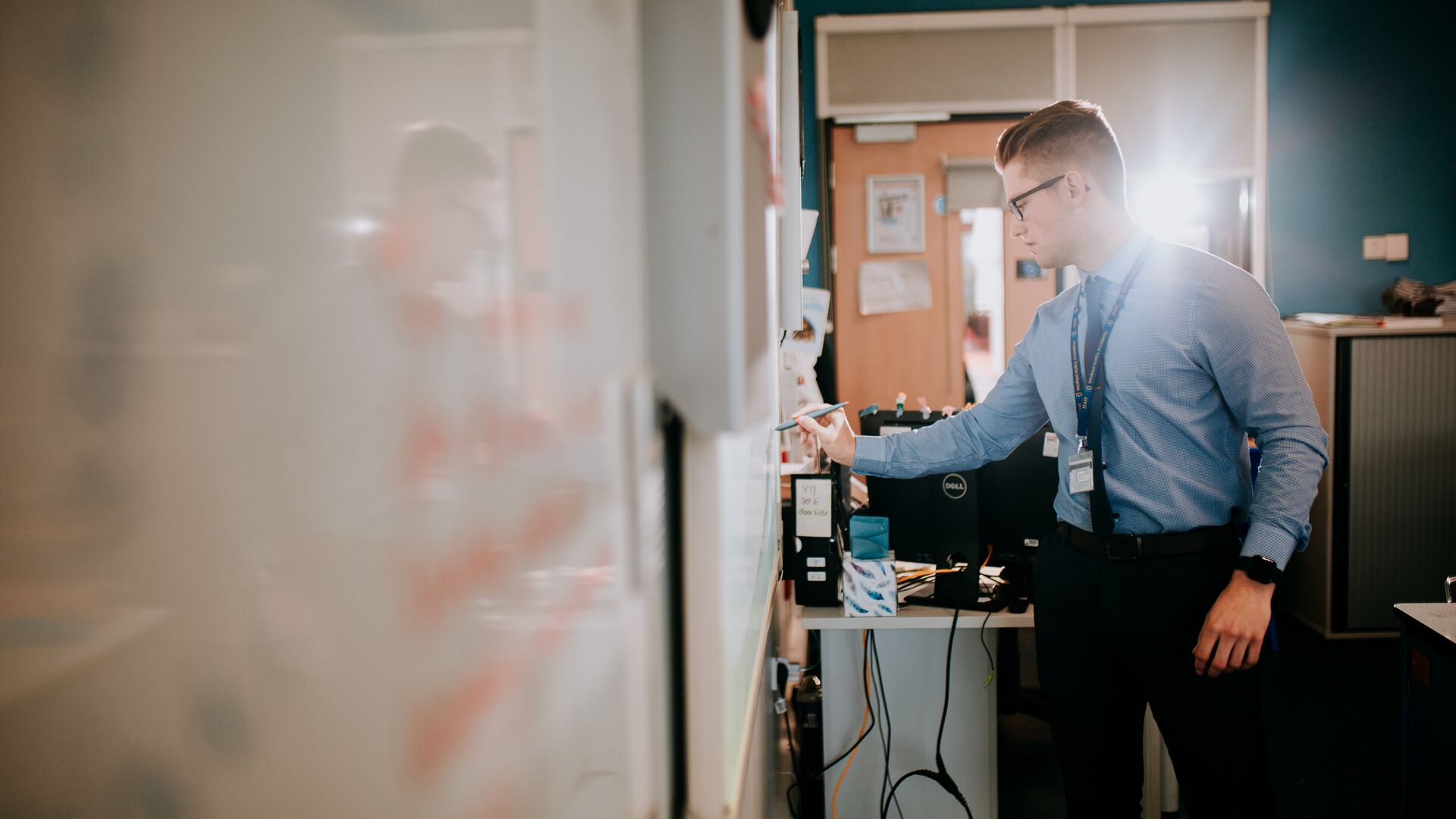 Student teacher writing on a whiteboard