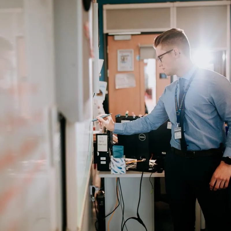 A student teacher writing on a whiteboard