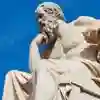 A white statue of Greek philosopher Socrates with a sunny blue sky behind