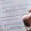 Student writing notes next to an equation