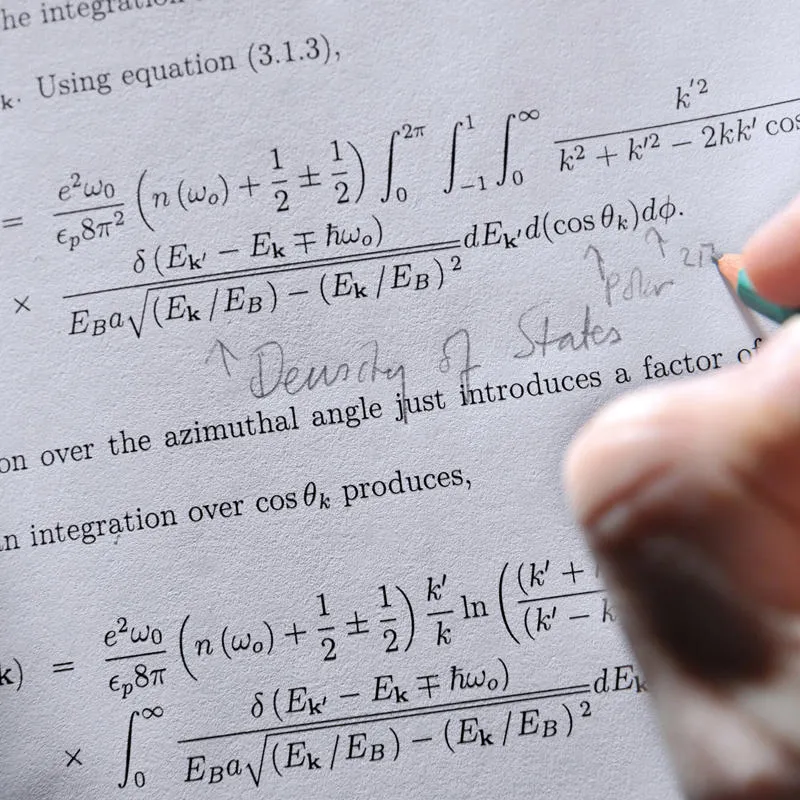 Student writing notes next to an equation