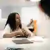 A group of marketing students chatting on chairs in a study space