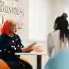 Two female students sitting around a table in the Business Lounge and chatting